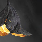 Close view of the dark textured shell and gold interior of this Clérachic pendant against a dark grey backdrop.