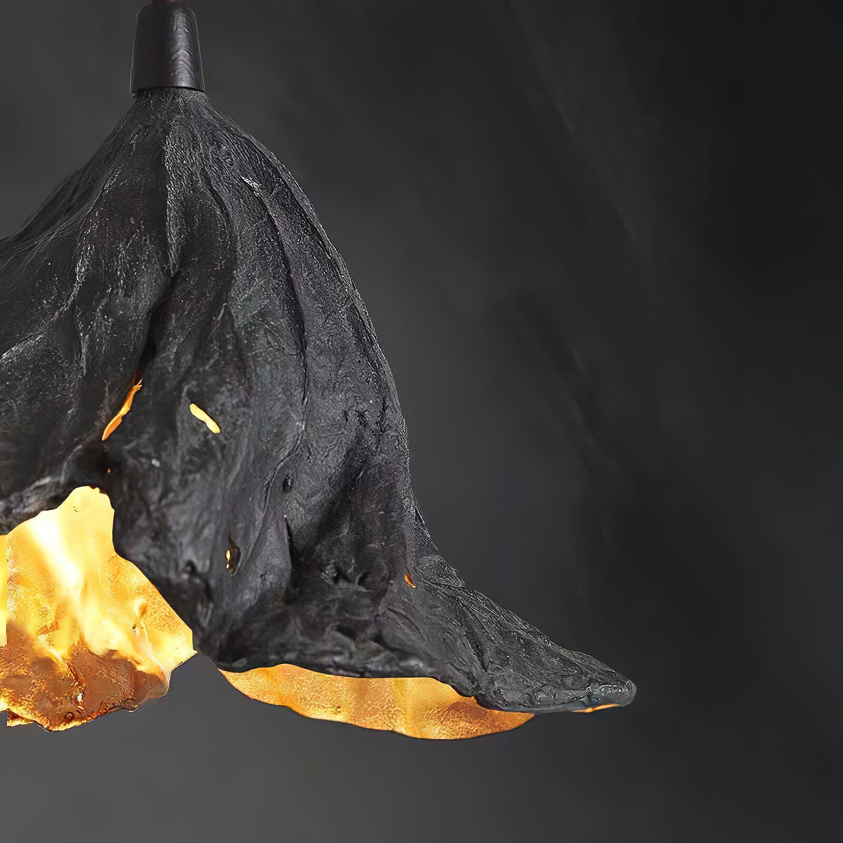 Close view of the dark textured shell and gold interior of this Clérachic pendant against a dark grey backdrop.
