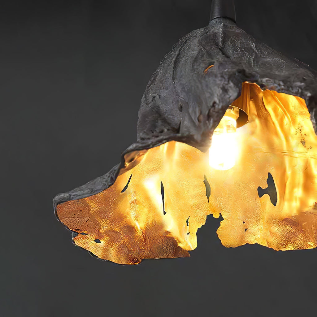 Close view of a lit bulb inside this Clérachic pendant's gold interior, set against a dark grey backdrop.