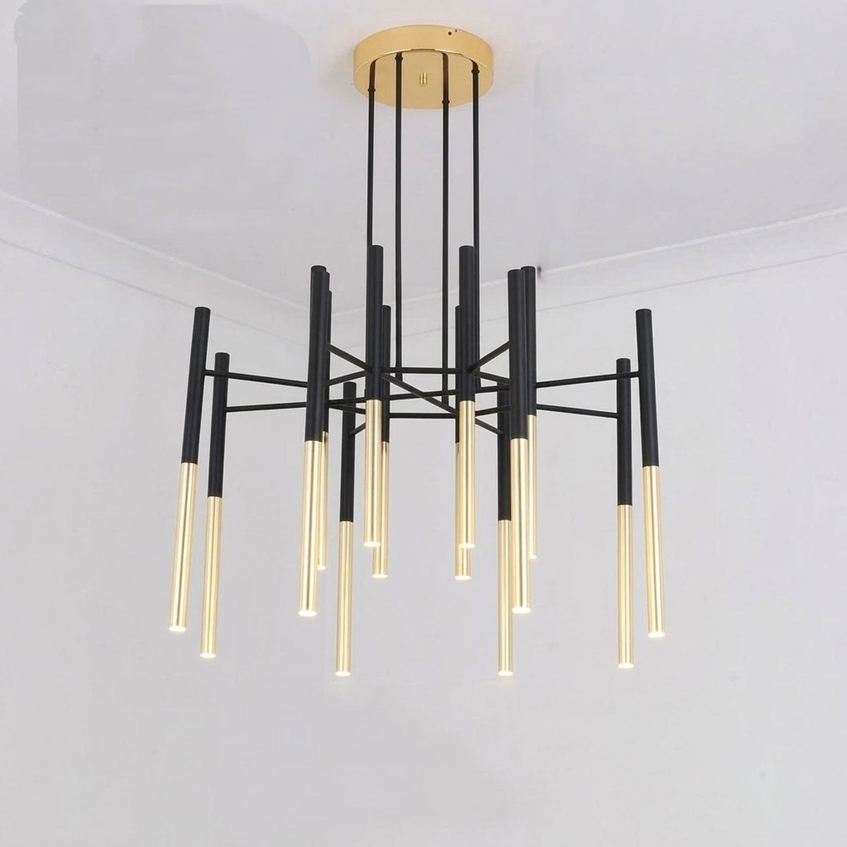 This Clérachic chandelier hangs from a brass-finish canopy, its black rods fanning out from the centre, in a plain white room.