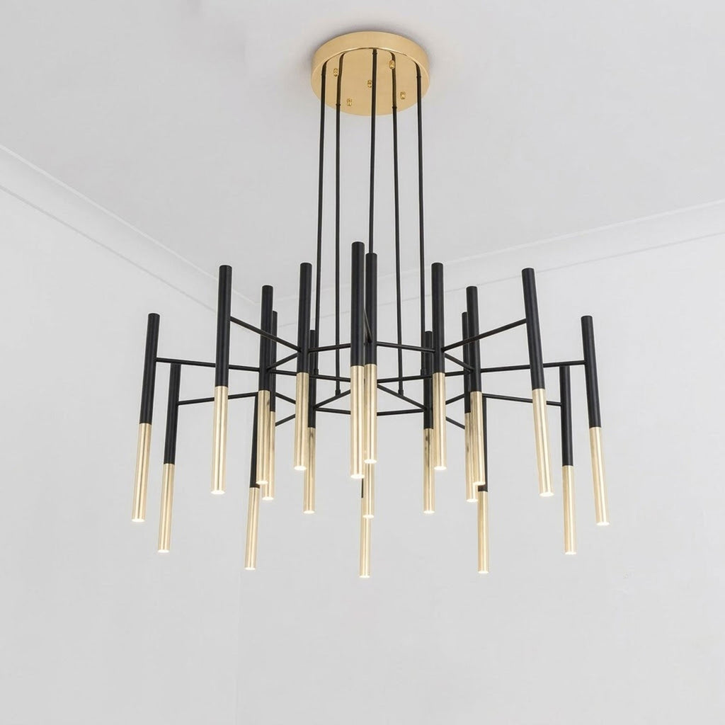 Seen from below in a white room, this Clérachic chandelier spreads its black arms and gold-tipped tubes outward from the canopy.