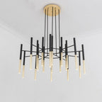 Seen from below in a white room, this Clérachic chandelier spreads its black arms and gold-tipped tubes outward from the canopy.