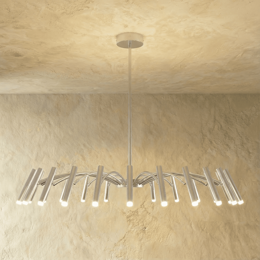 A fuller silver-toned chandelier spreads arched arms and many cylindrical heads, each catching warm light in this Clérachic hero shot.