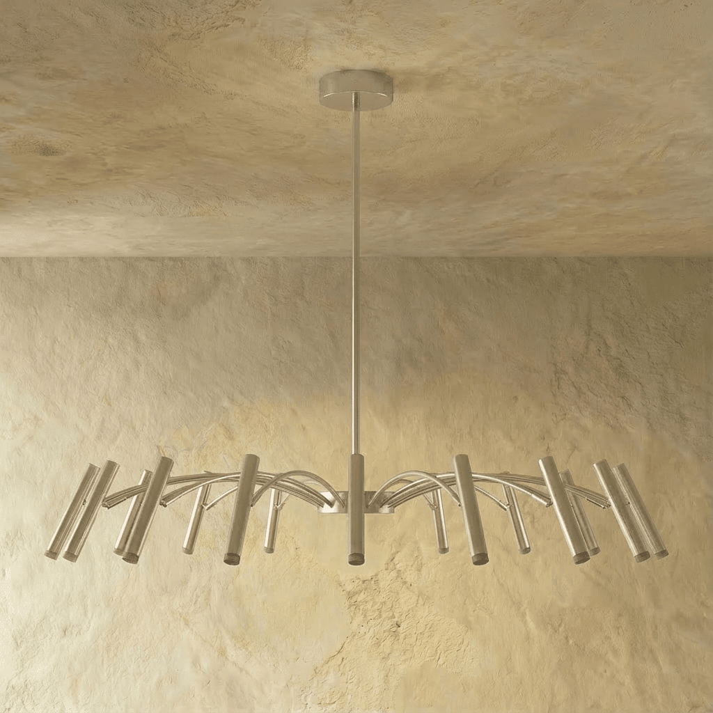 The silver-toned chandelier's shorter arm spread and tube heads are shown at an angle against a plaster wall in this Clérachic hero shot.