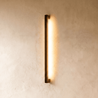 The black column wall light's warm vertical glow is shown against plaster in another angle of this Clérachic hero series.