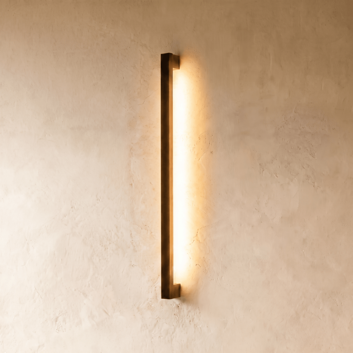 The black column wall light's warm vertical glow is shown against plaster in another angle of this Clérachic hero series.