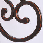 Close view of the scrolled dark bronze metal arm on this Clérachic wall lamp, with a copper edge along the curl.