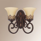 Front view of a two-arm Clérachic wall lamp on a beige backdrop, showing the oval backplate and the scrolled arms.