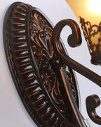 Close view of the ribbed oval backplate of this Clérachic wall lamp, with a scrolled arm and a shade above.