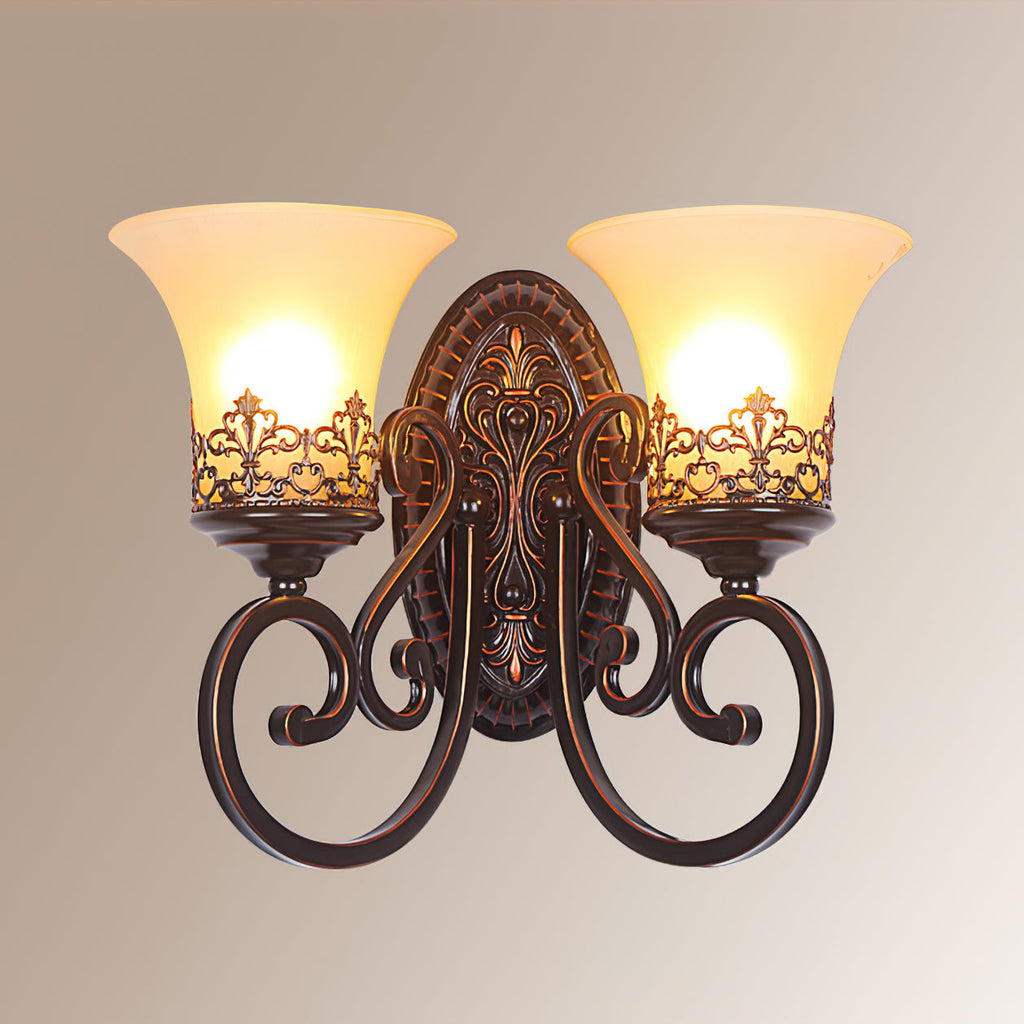 A lit two-arm Clérachic wall lamp on a warm gradient backdrop, with glowing bulbs inside the cream glass shades.