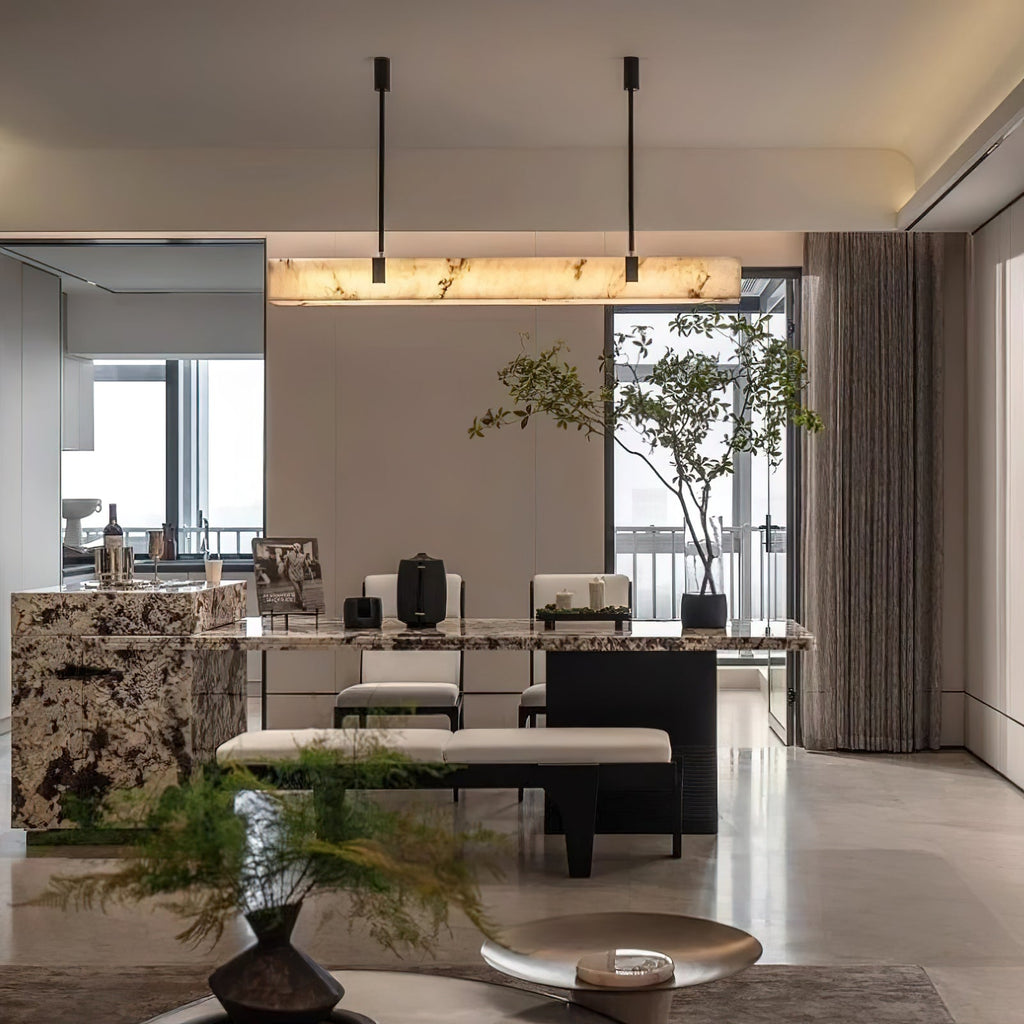 Wide dining room view of the Clérachic Black Linear Chandelier lighting a marble table set with chairs and a bench.