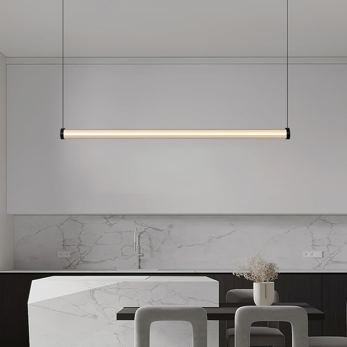 This Clérachic linear pendant hangs in front of a marble kitchen splashback and an angular stone island with grey stools.