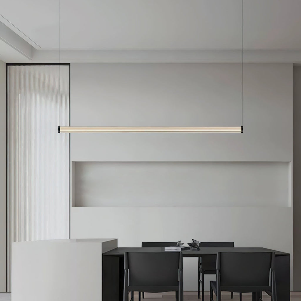 Warm light glows from this Clérachic linear pendant above a black dining table, in front of a pale grey wall niche.