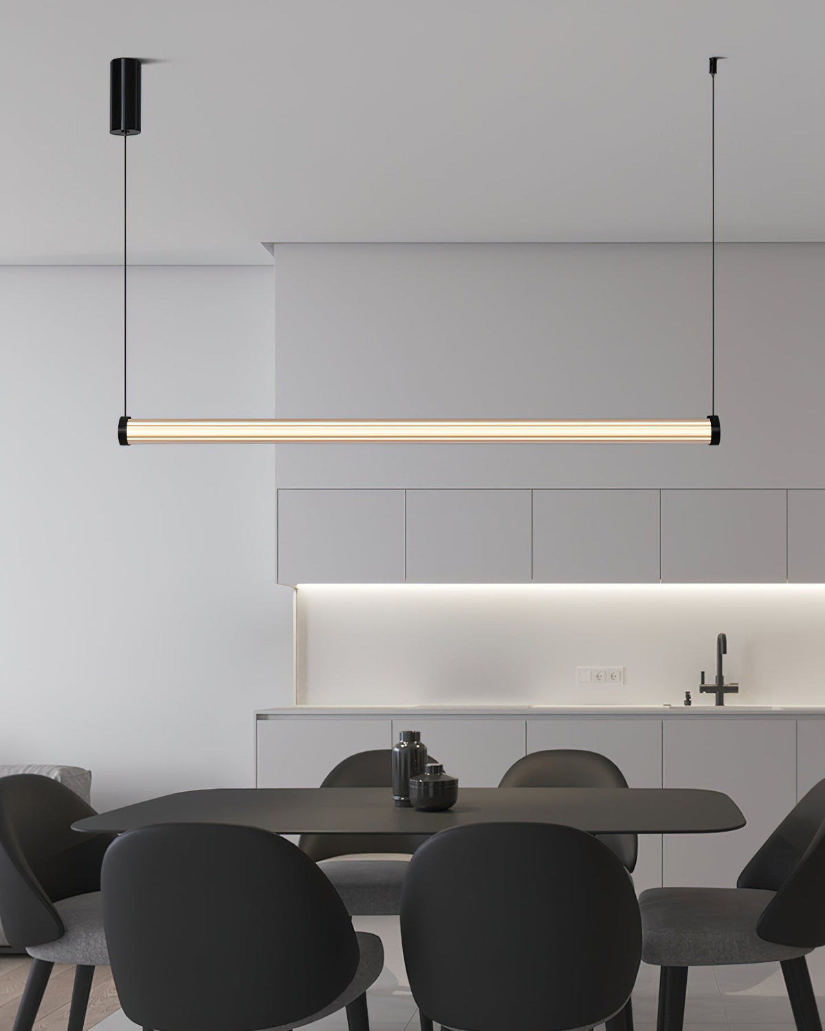 Level above a dark dining table with round-backed chairs, this Clérachic linear pendant sits in front of pale kitchen cabinets.