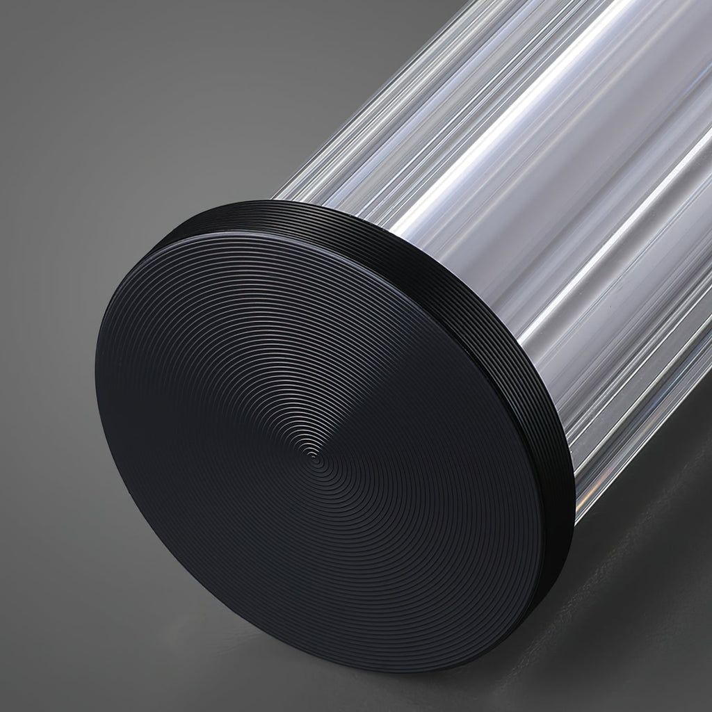 Close view of the black end cap on this Clérachic linear pendant, with fine concentric rings and the ribbed clear tube behind it.