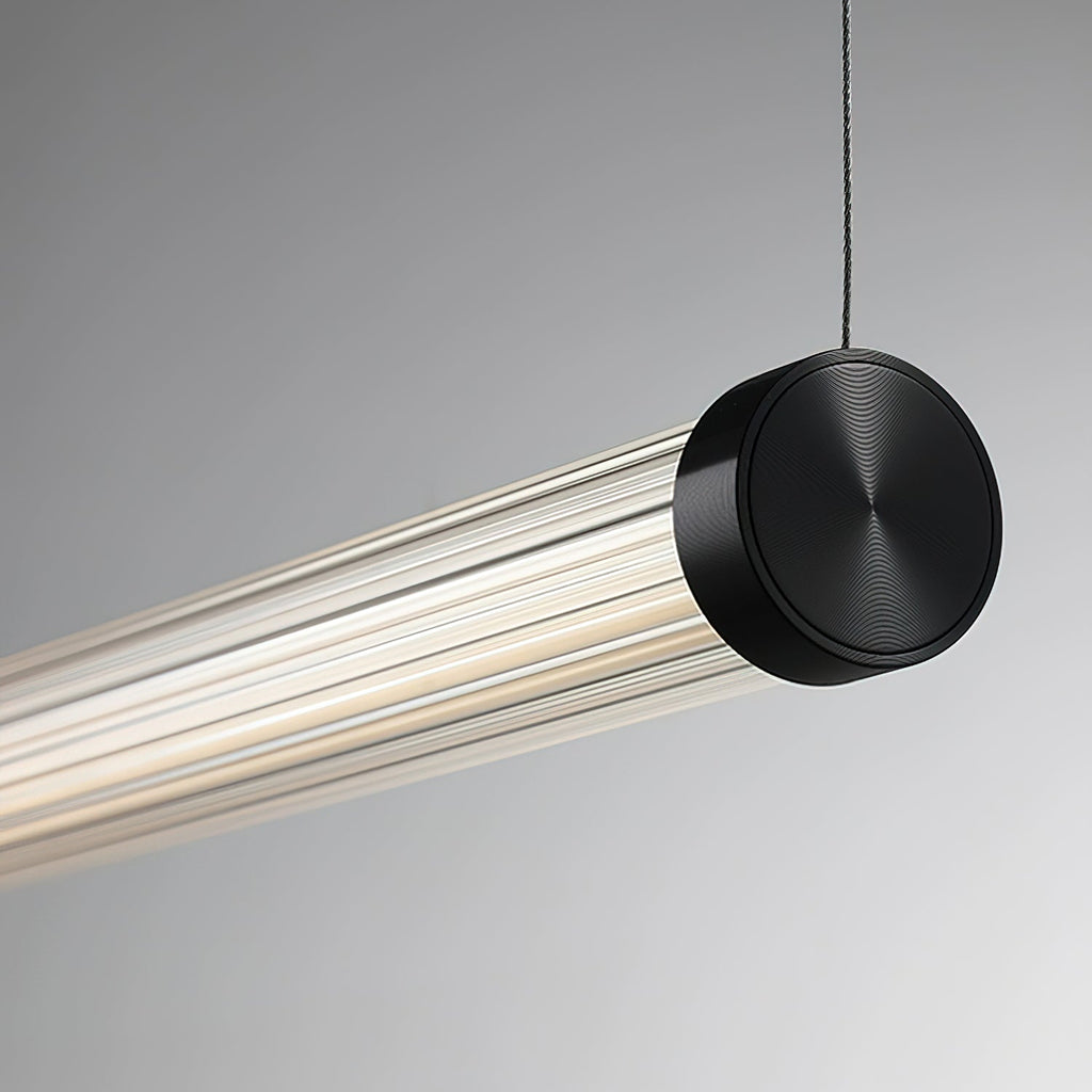 A Clérachic linear pendant on a pale grey backdrop, its black end cap with a ringed finish hung from a thin dark cable.