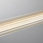 Close view of the vertical ribbing on the clear tube of this Clérachic linear pendant, lit warm from inside.