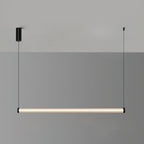 A level Clérachic linear pendant lit warm against a two-tone grey wall, with its black canopy and cable at either end.