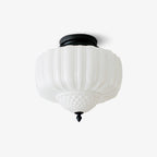 Black and white flush ceiling light from Clérachic with a ribbed milk glass shade, a quilted lower bowl and a small black finial, on white.