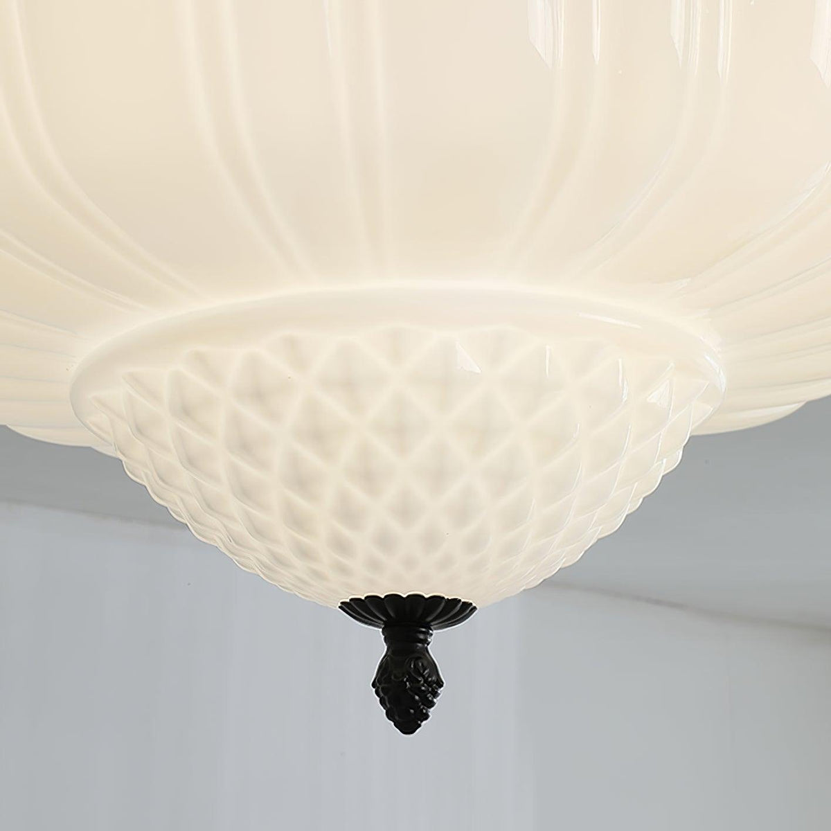Close view of the quilted lower bowl and black acorn finial on this Clérachic ceiling light.