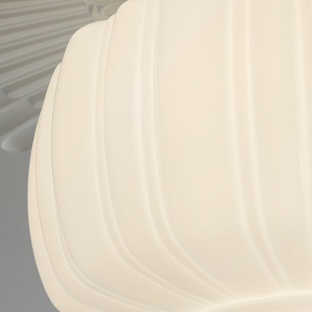 Side close view of the ribbed edge of this Clérachic ceiling light's glass shade, glowing a creamy white.