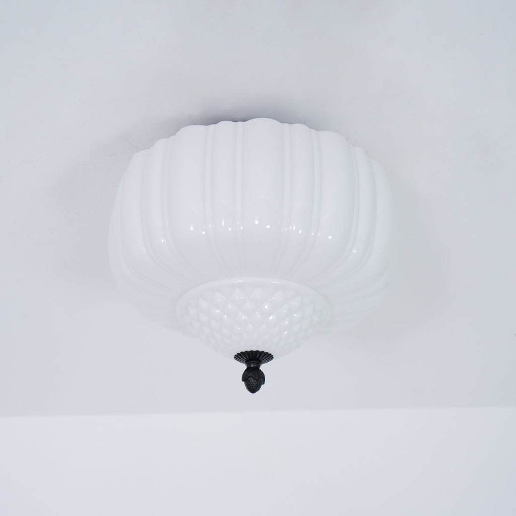 Unlit ribbed white glass ceiling light from Clérachic with a quilted lower bowl, seen from below on a pale ceiling.