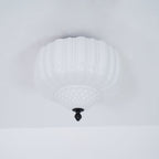 Unlit ribbed white glass ceiling light from Clérachic with a quilted lower bowl, seen from below on a pale ceiling.