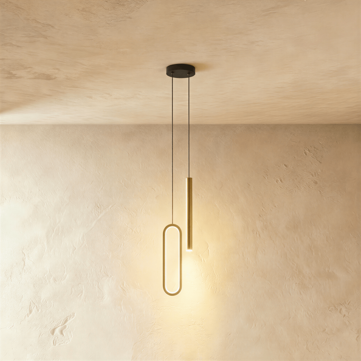 A brass-toned version of the pendant shows the same oval ring and rod pairing, both glowing warm in this Clérachic hero shot.