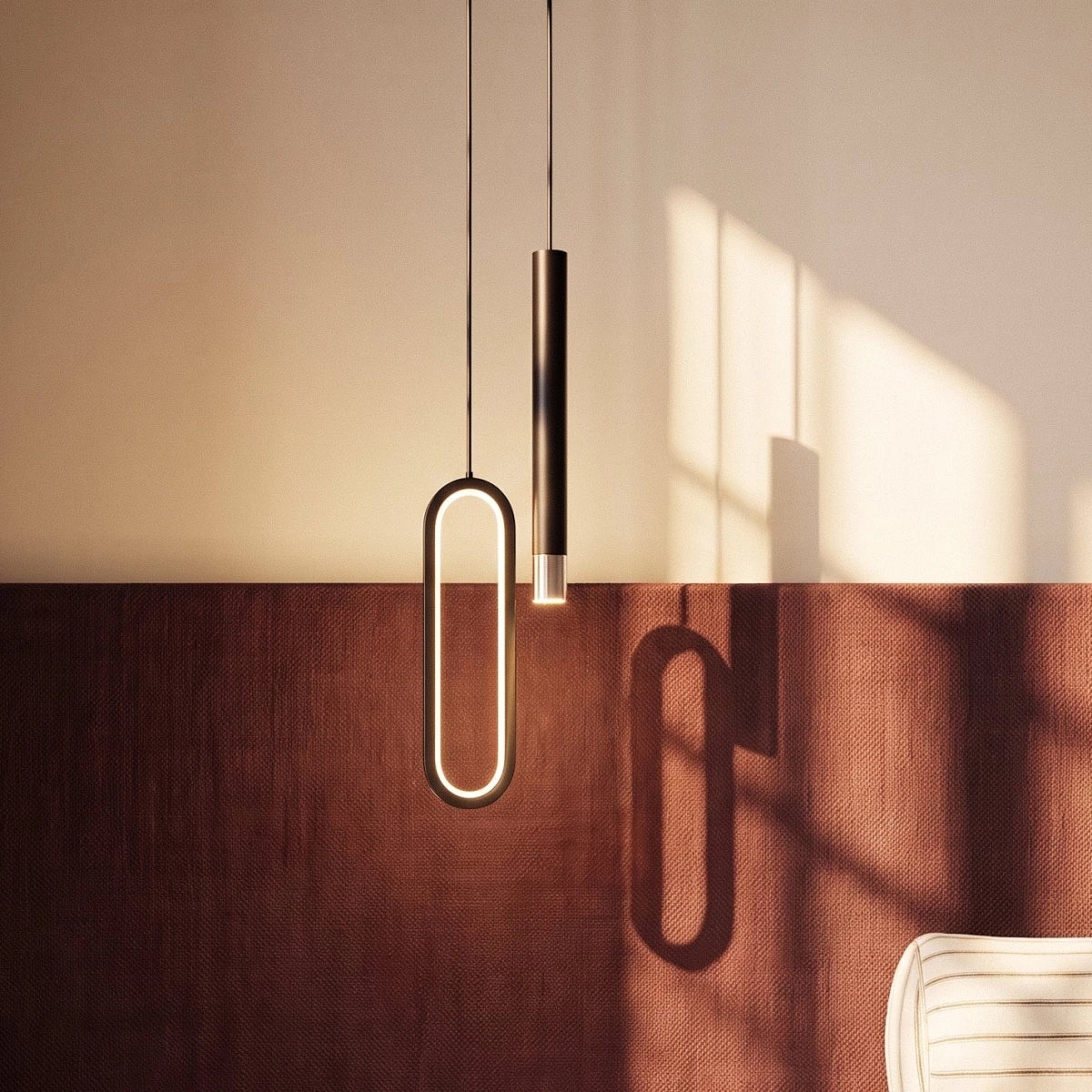 A closer crop shows the black pendant's glowing oval ring and rod casting shadows on a rust-toned headboard, Clérachic lifestyle shot.