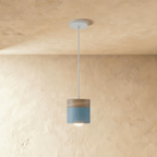 Clérachic light blue pendant light with a wood top, its small cylindrical shade glowing warm on a slim cord.