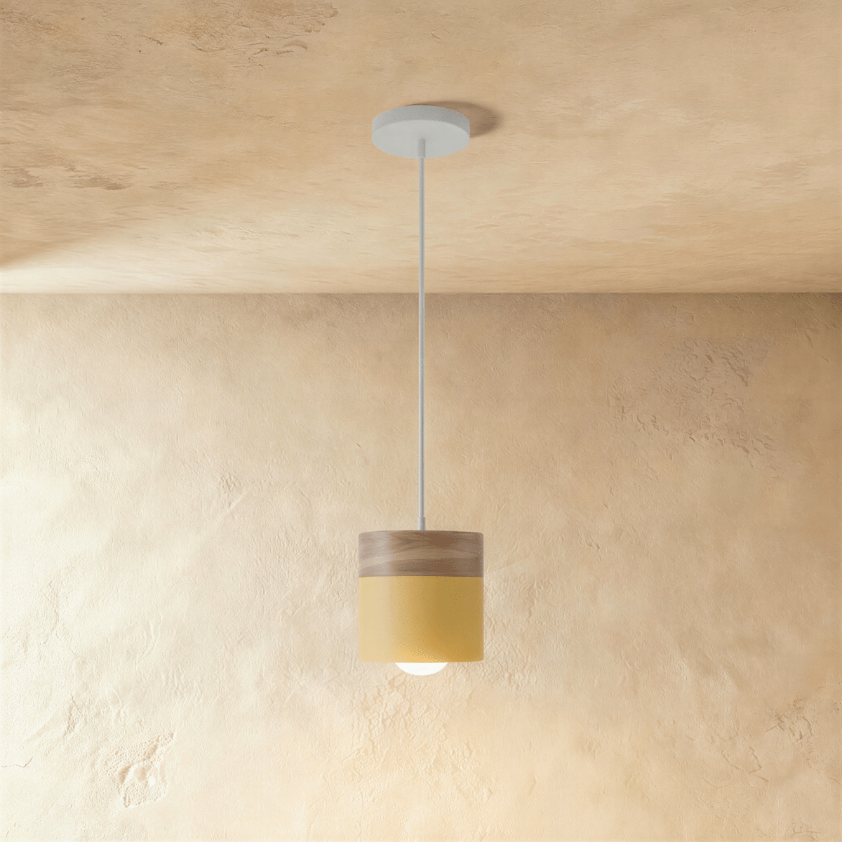 Clérachic mustard yellow pendant light with a wood top, its cylinder shade glowing warm on a white ceiling cord.