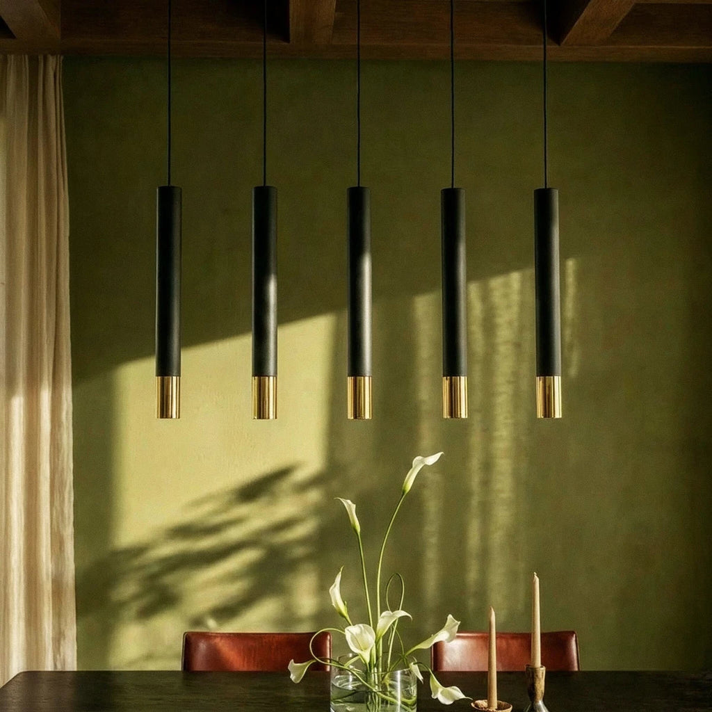 Clérachic black pendant cluster with gold rim tips lights a table set with lilies and candles against a green wall.