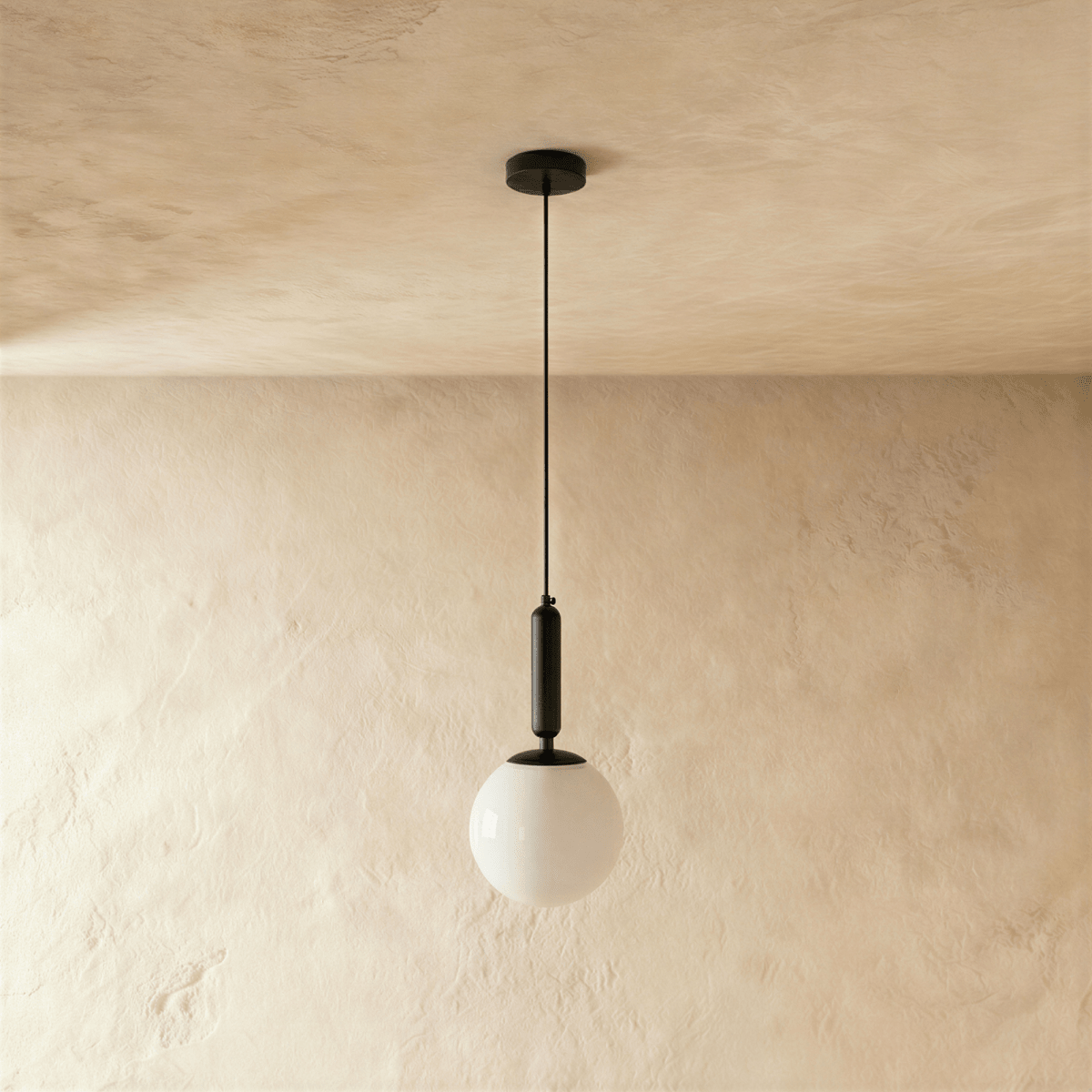 Clérachic black metal pendant light with a glossy white globe shade, suspended from a round ceiling canopy.