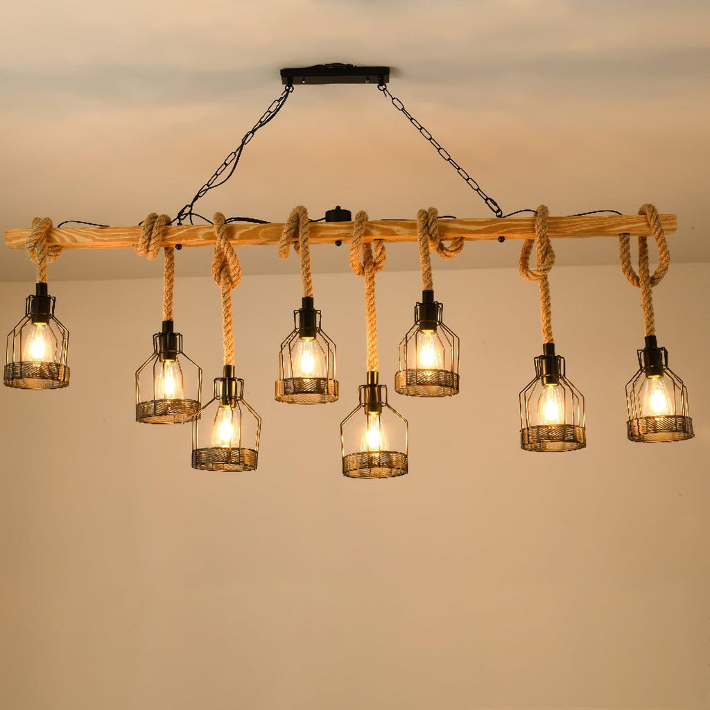 A longer Clérachic pendant light with eight lit caged bulbs hanging at staggered heights from a wooden beam under a warm ceiling.
