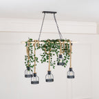 Clérachic pendant light with a pale beam draped in green leaf garland, five unlit cages hanging below on hemp rope.