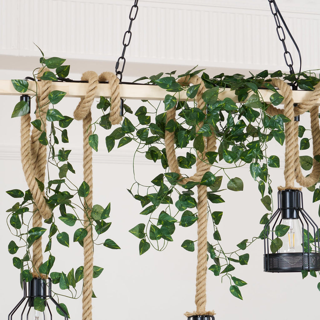 Close view of green leaf garland wound through the hemp rope and beam of this Clérachic pendant light.