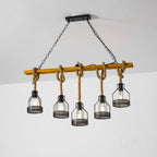 Clérachic pendant light with five caged bulbs, hanging at staggered heights on knotted rope from a warm wooden beam.