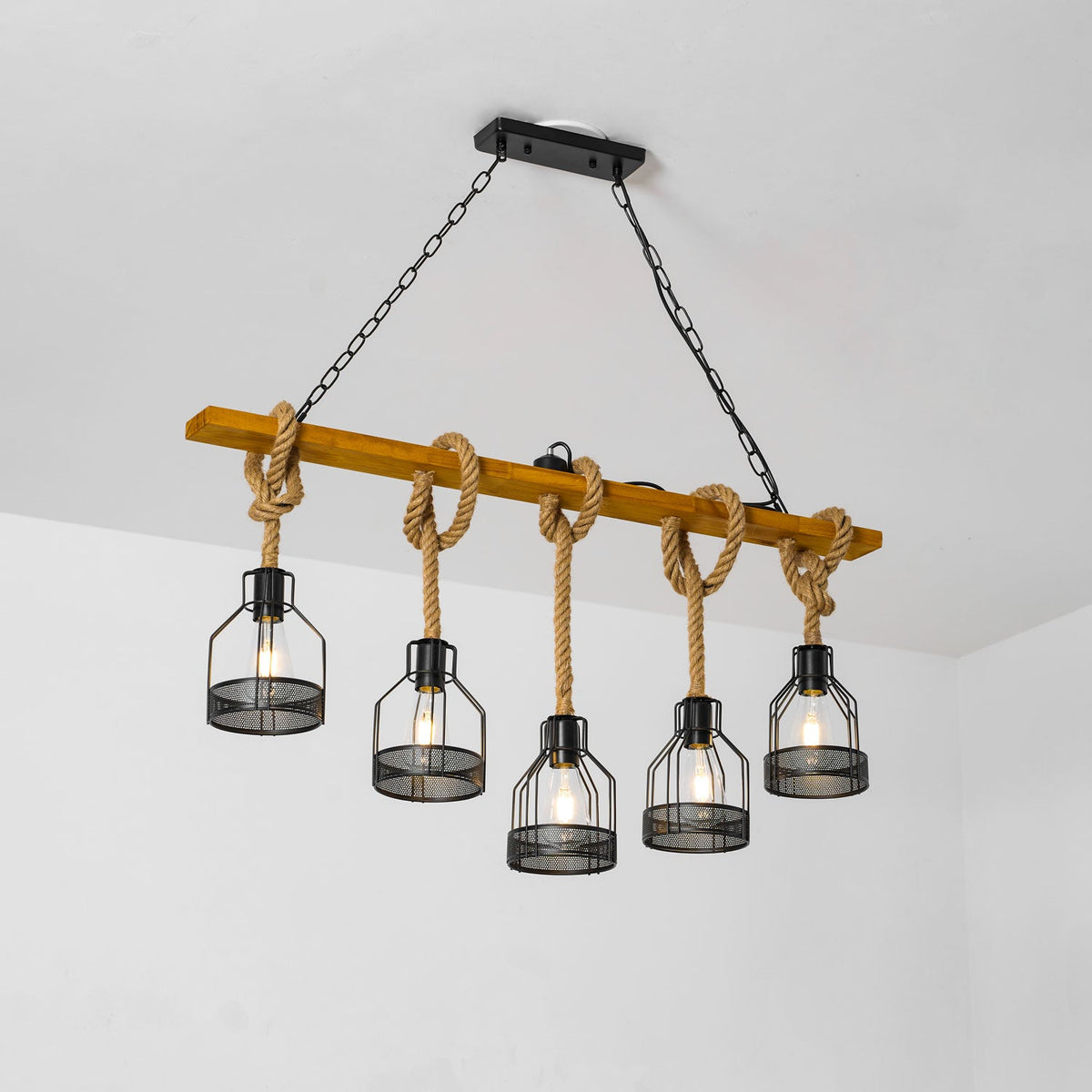 Clérachic pendant light from a three-quarter angle, with its knotted ropes and five cages hanging from a tilted beam.