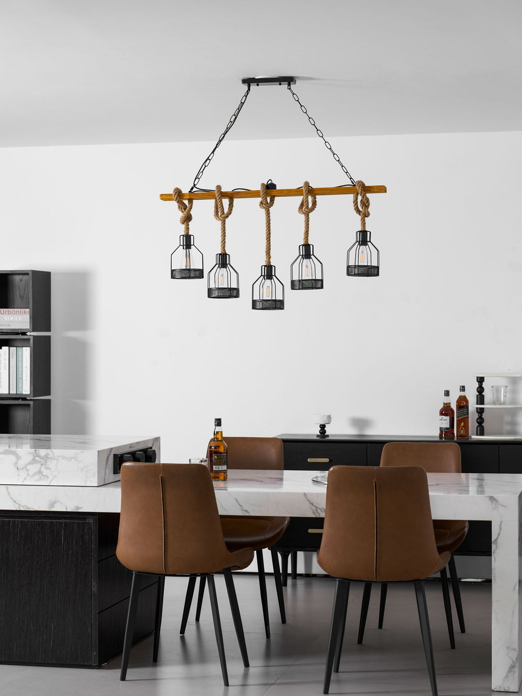 Wide view of a Clérachic pendant light above a marble table and brown leather chairs in a modern white room.