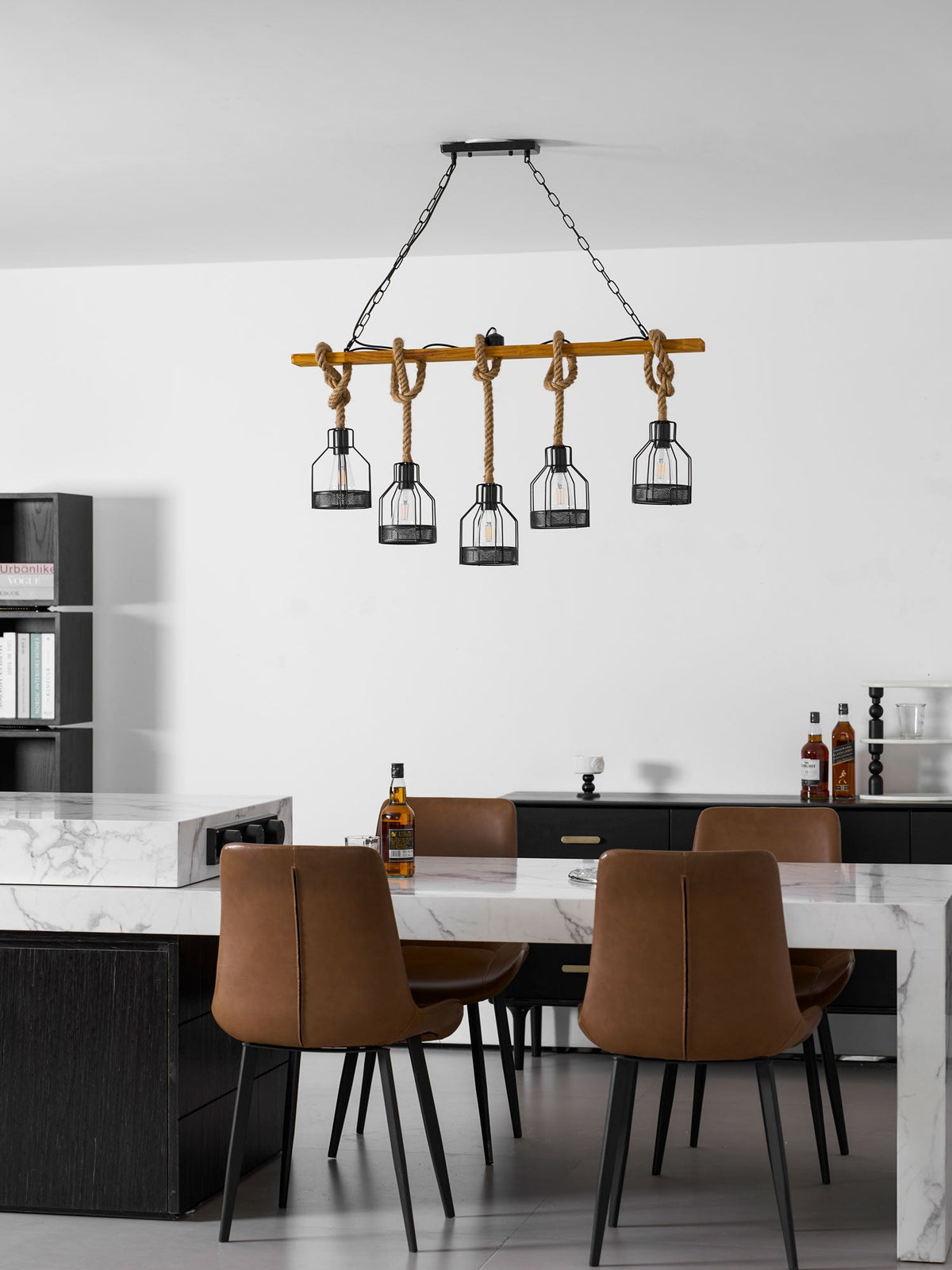 Wide view of a Clérachic pendant light above a marble table and brown leather chairs in a modern white room.