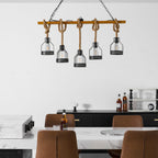 Close crop of a Clérachic pendant light with five caged bulbs on hemp rope, with a marble counter at the bottom of the frame.