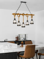 Clérachic pendant light shown narrower in the frame, above a marble counter, tan chairs and a bottle of whisky.