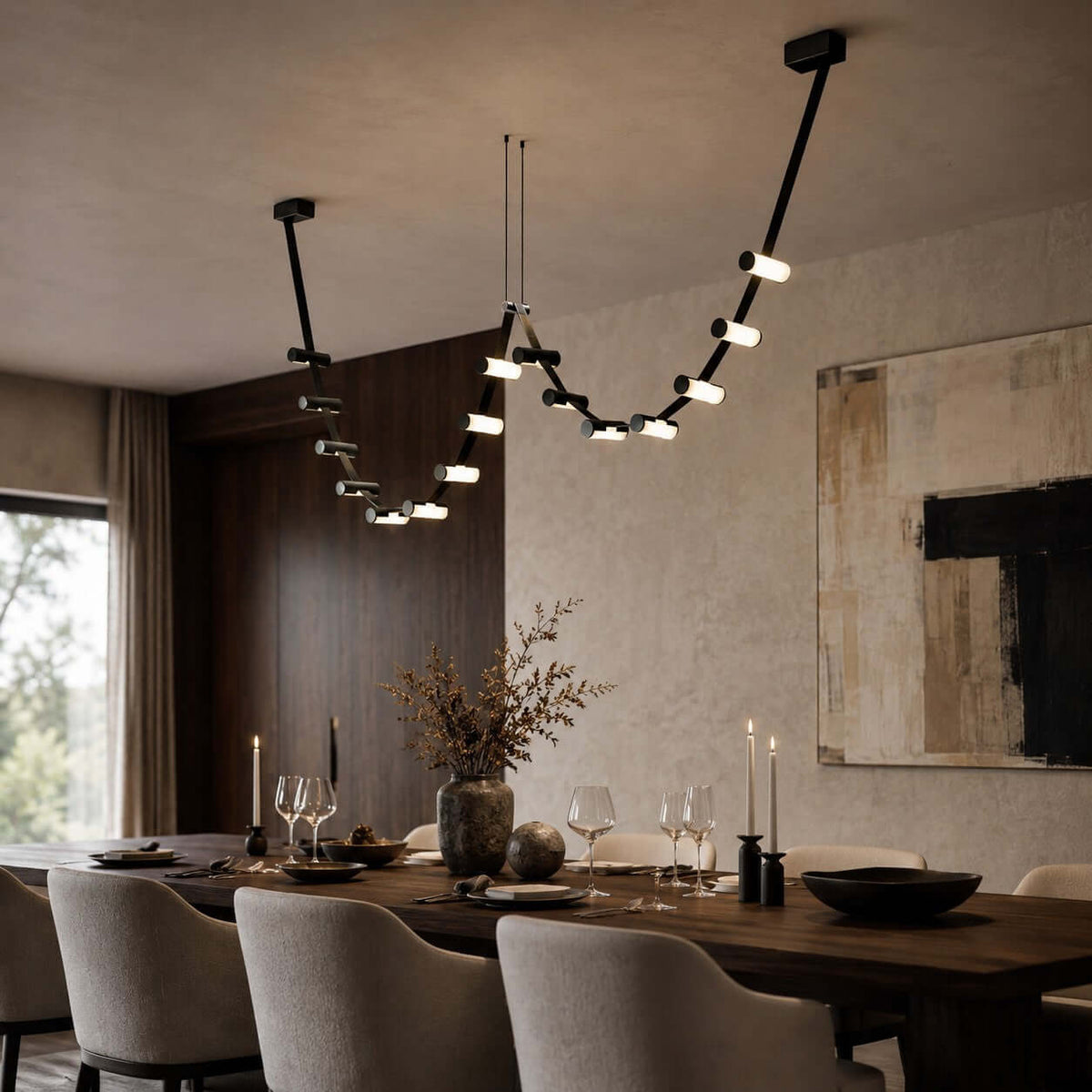 Clérachic black pendant light with glowing cylinders hung above a candlelit dining table, with a dark wood wall and abstract art.