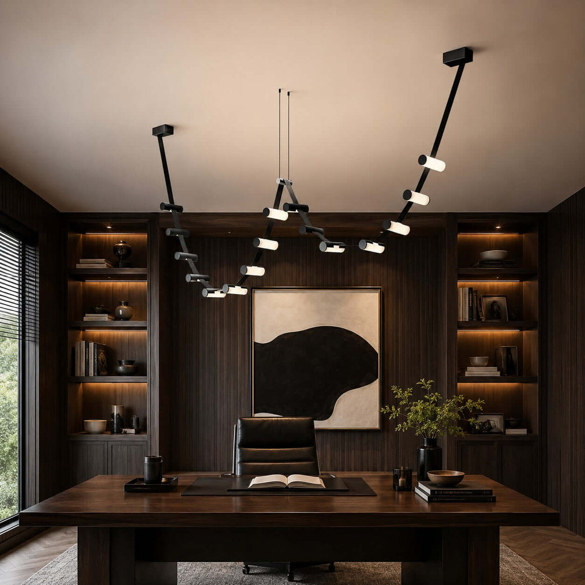 Clérachic black linear pendant in a dark study with built-in lit shelves, a wide wooden desk and a large abstract print.