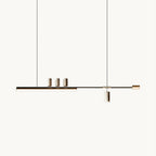 Long horizontal LED bar with three small brass-toned spots and a hanging cylinder, this Clérachic pendant on a plain white backdrop.