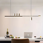 Slim lit bar of this Clérachic pendant hung over a white dining table with a laptop, a bottle and fruit below.