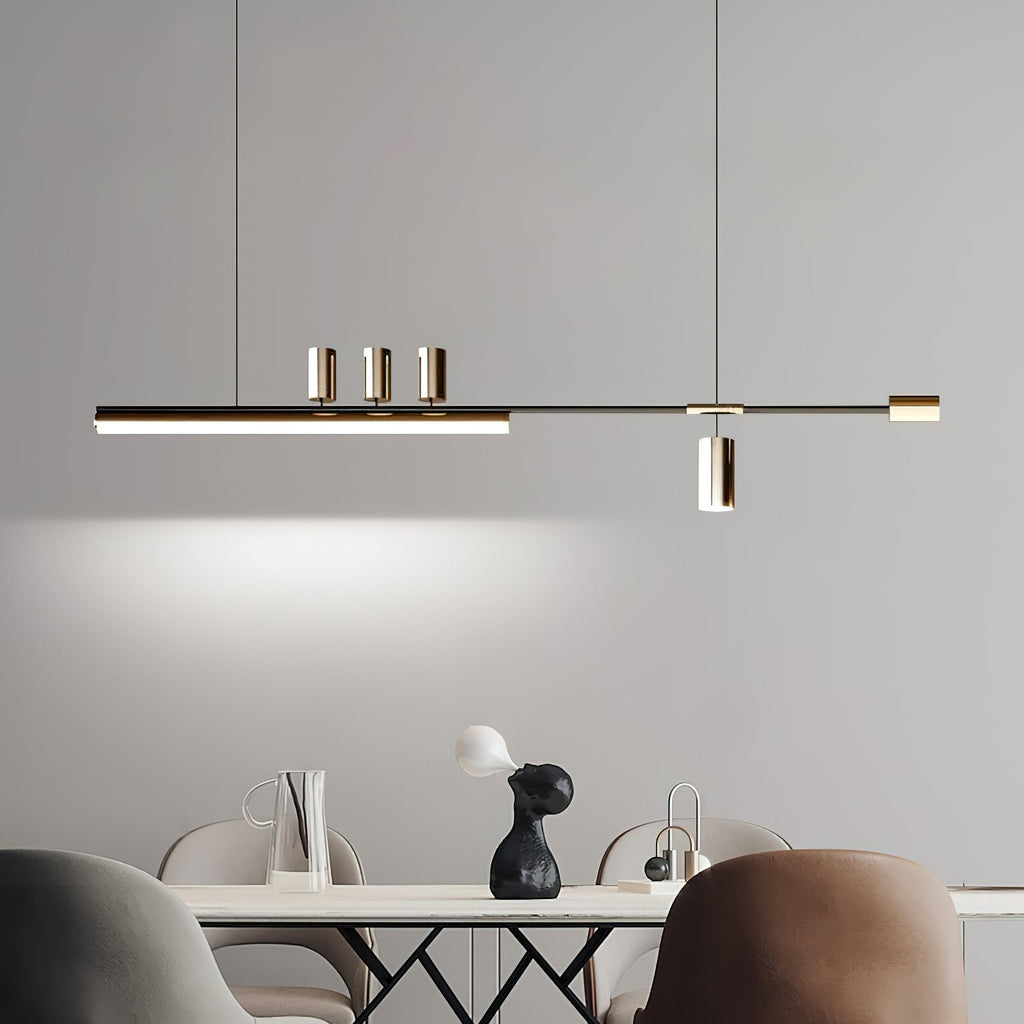 Lit strip with three small spots and a hanging cylinder, a Clérachic pendant on a grey wall above a table and leather chairs.