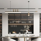 Lit bar and hanging cylinder of this Clérachic pendant above a set dining table, with a glass-fronted display cabinet behind.