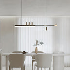This Clérachic pendant glows above a white dining table and cream chairs, with sheer floor-length curtains behind.