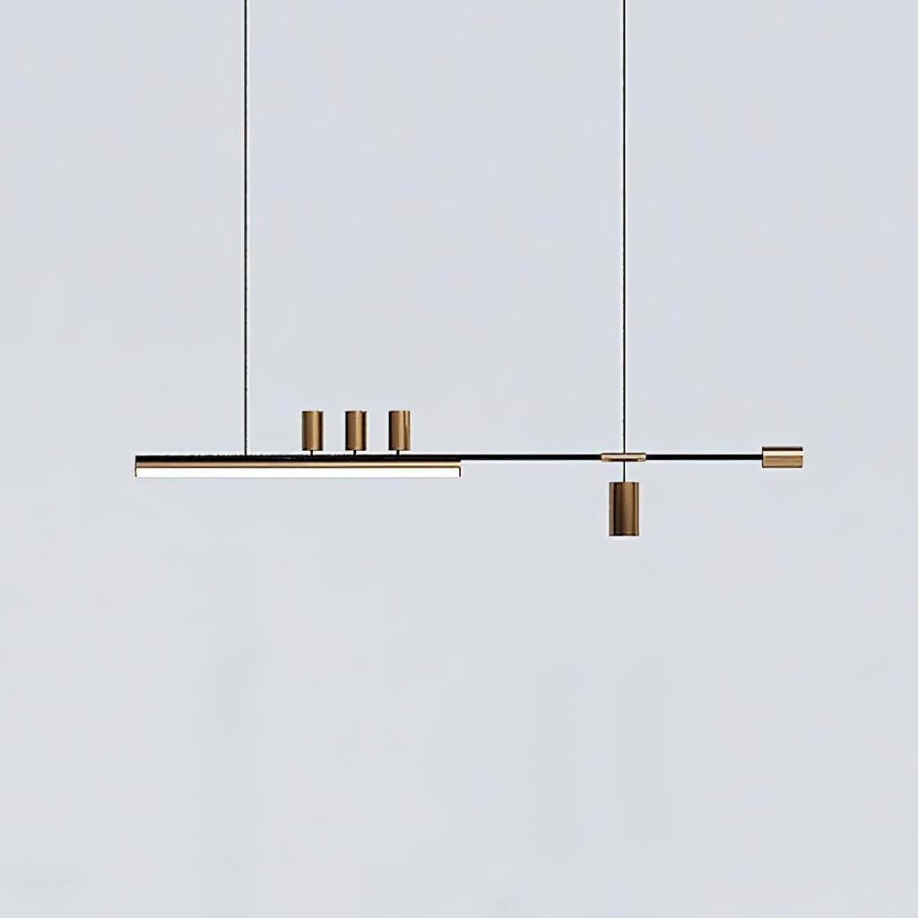 This Clérachic pendant on a cool pale-grey backdrop, showing the lit bar, three brass-toned cylinders and a hanging spot.